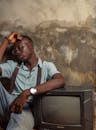 Man sitting beside a Television