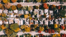 House roofs between colorful autumn trees and roads