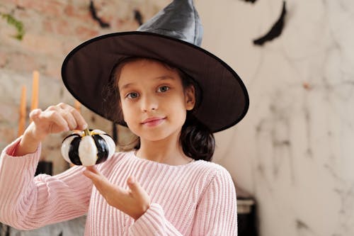 Girl Holding A Pumpkin Painted In Black And White