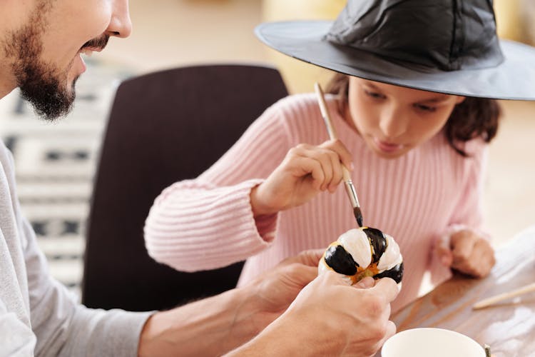 Girl Painting A Pumpkin With Black And White