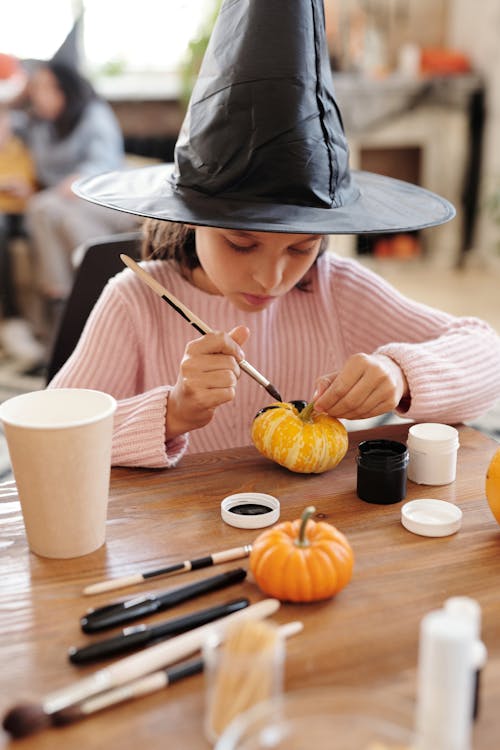 Free Girl in Pink Painting A Pumpkin Stock Photo