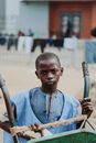 Pensive black boy with weathered wheelbarrow