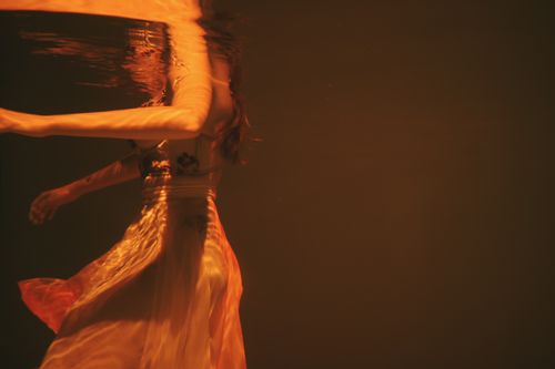 Free Artistic underwater photo of a woman in flowing dress, capturing motion and reflection. Stock Photo