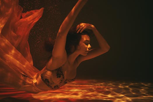 水下艺术形象中的女性身着流动的服装，在柔和的光影中展现