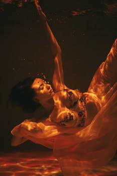 一位身着飘逸服装的美丽女子在水下宁静地摆出姿势拍摄