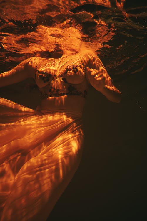 A Person Submerged in Water Wearing a Brassiere and a Skirt