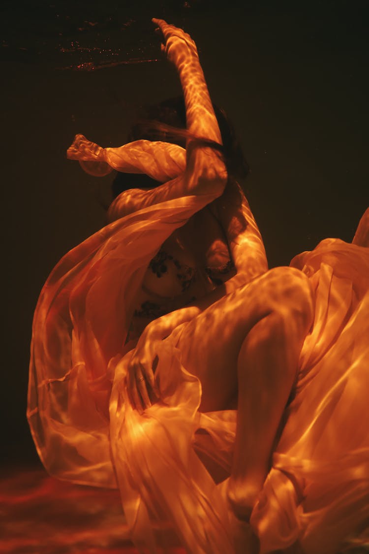 A Woman In A Sheer Skirt Underwater