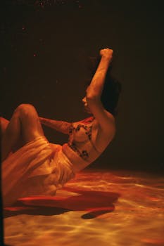 温暖而戏剧性的灯光下，一位女子优雅地浸在水中