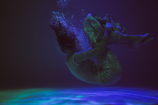 一张艺术水下照片中，一个人优雅地漂浮在深蓝色的水中，画面迷人而宁静