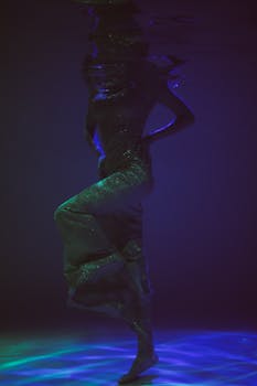 水下艺术摄影以戏剧性的灯光捕捉了一位姿态优雅的女性