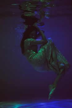 一位女子优雅地沉浸在水下，镜头中的艺术氛围宁静而梦幻