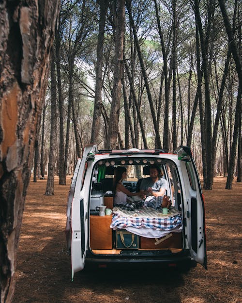 Free Couple sitting on a Camper Van  Stock Photo