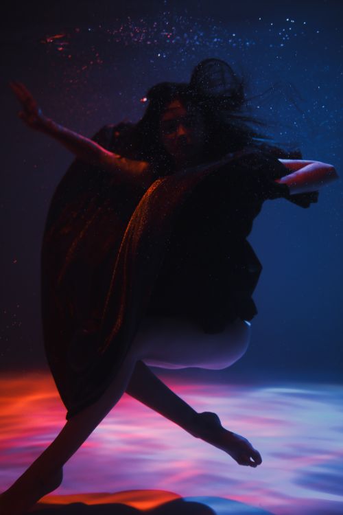 Free Artistic underwater dance capturing fluid motion and vibrant colors in a surreal setting. Stock Photo
