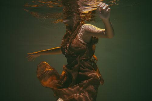 Free Elegant underwater photo of woman in flowing dress, enveloped in serene waterscape. Stock Photo