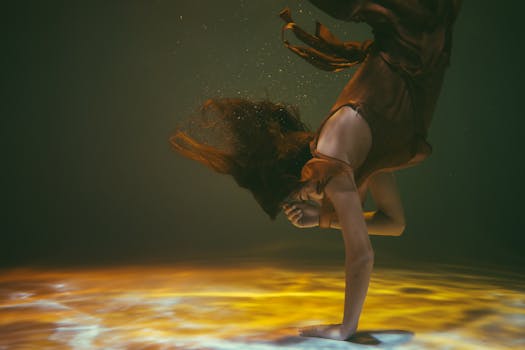 一名女子在水下优雅地摆着姿势，空灵的光线和流畅的动作笼罩着她