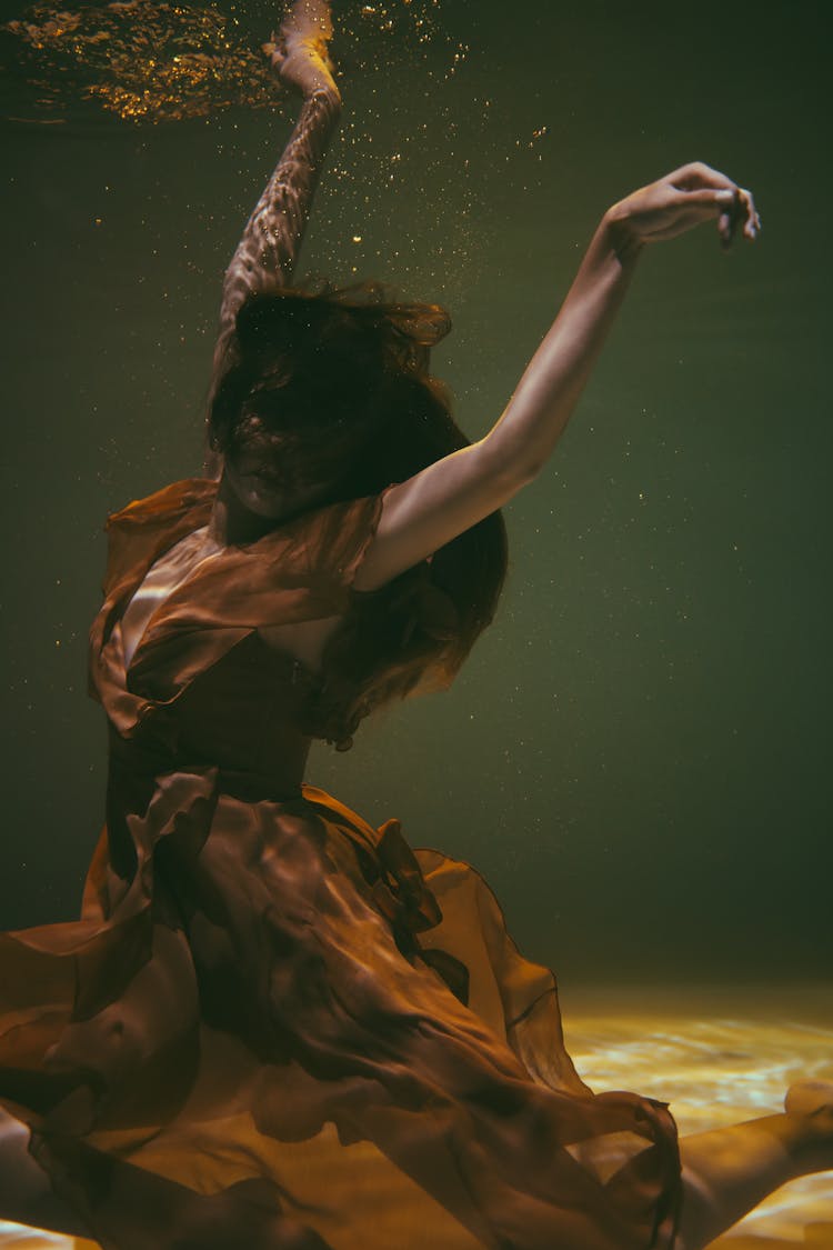 Graceful Woman With Her Arms Raised Underwater 