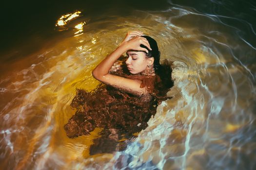 一位女子闭目静立，姿态优雅，沉浸在泛起涟漪的水中