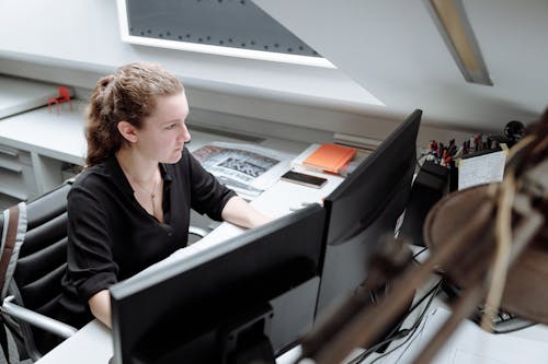 Free A Woman in Black Long Sleeves Using a Desktop Computer Stock Photo