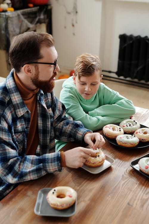 Pai Mostrando Seu Filho Para Decorar Um Donut