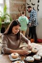 一家人在室内制作圣诞主题甜甜圈，享受节日准备的乐趣