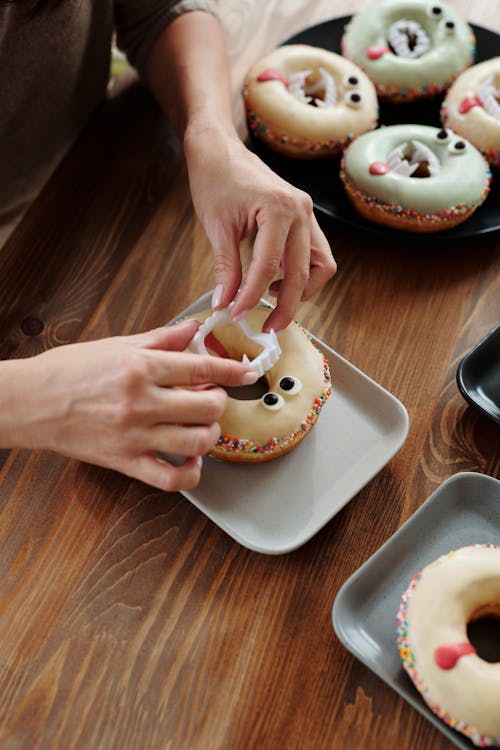 Pessoa Segurando Uma Placa De Cerâmica Branca Com Donut Branco E Marrom