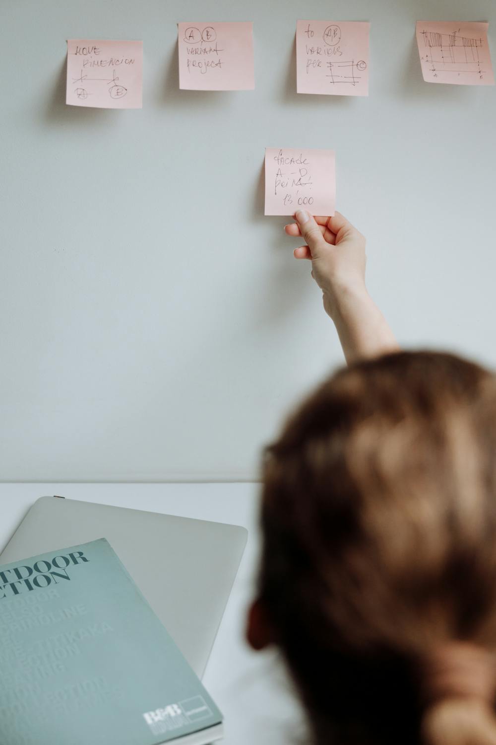 Person picking a Sticky Note from the Wall · Free Stock Photo