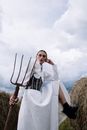 Elegant Woman in White Dress holding a Pitchfork