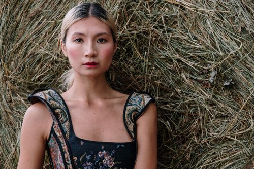 Free Portrait of a fashionable woman against a hay backdrop, blending elegance and rustic charm. Stock Photo