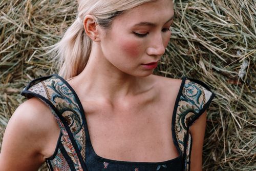 Free Close-up portrait of a woman in a stylish dress against hay backdrop. Stock Photo