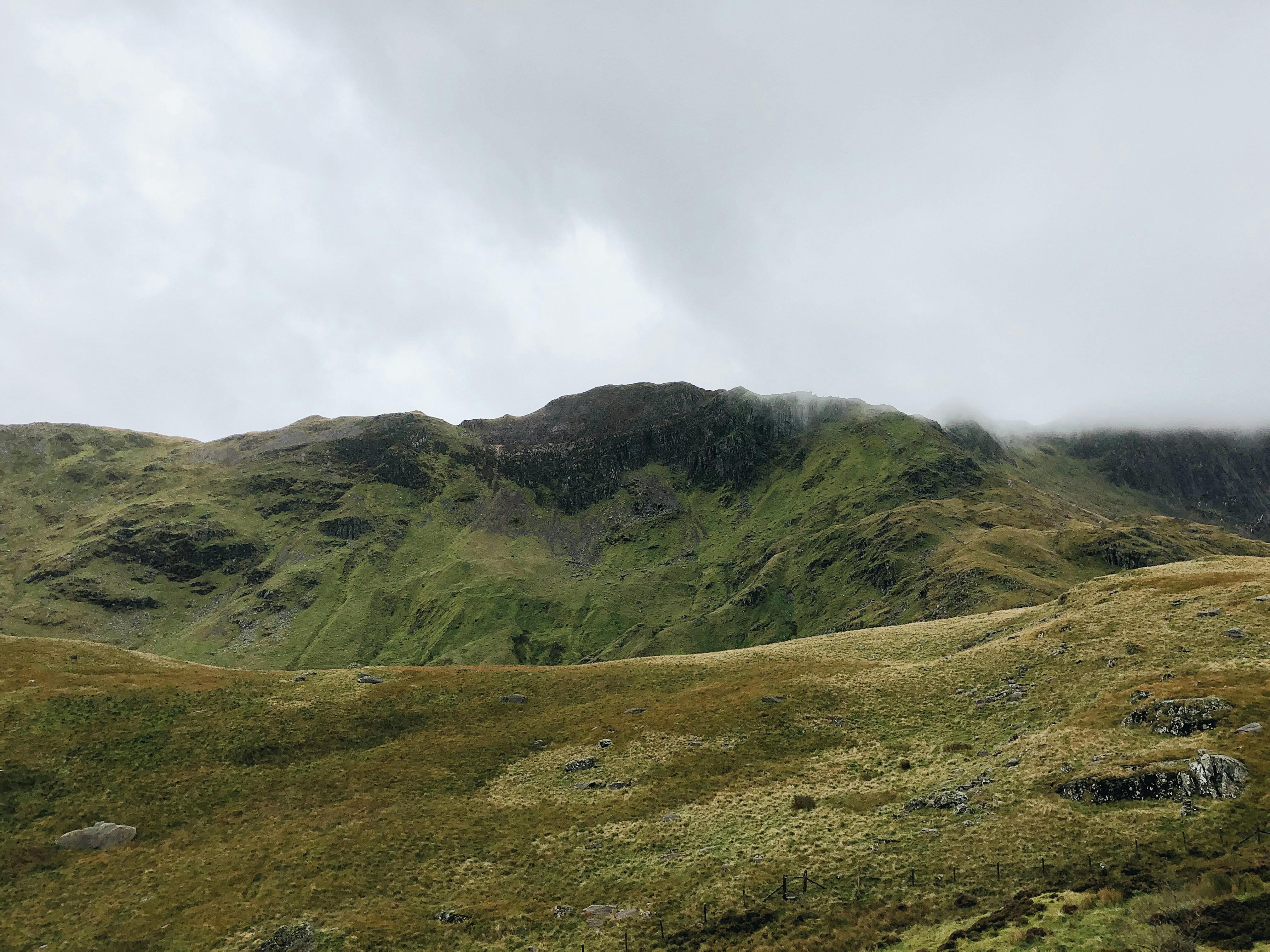Explore the lush green landscapes of Gwynedd, Wales under a moody cloudy sky.