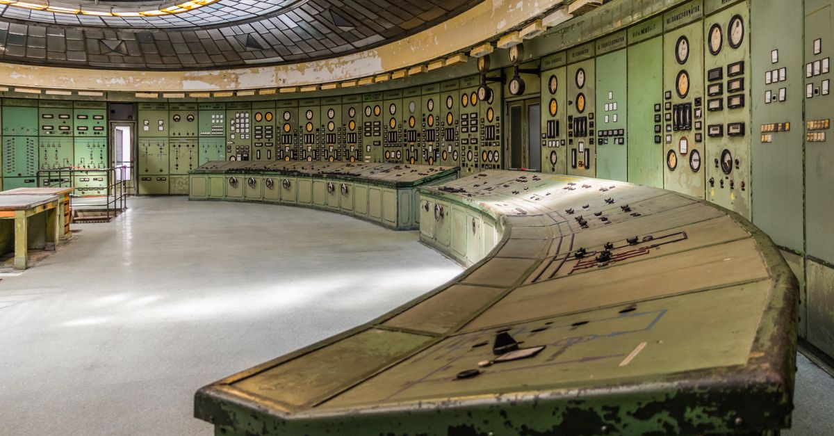 Retro industrial control room with vintage panels and dials in an old power plant.