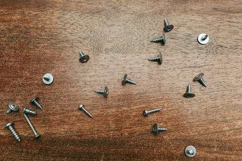 Silver Screws on a Wooden Surface