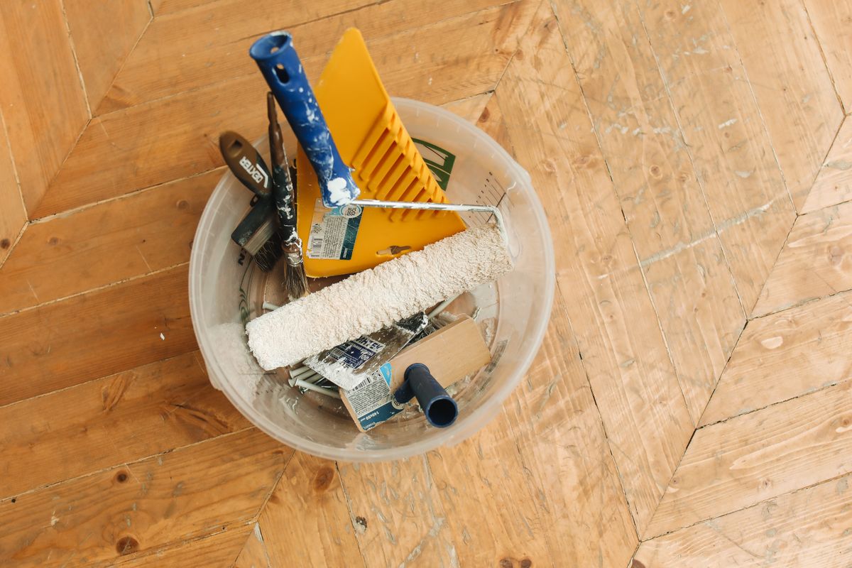 Generic scraper, roller and brushes in a bucket for roof preparation