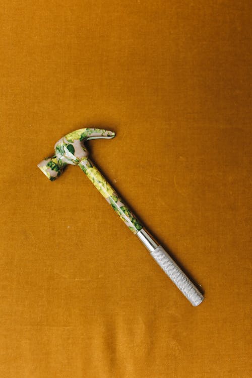 Hammer in Paint on Yellow Background
