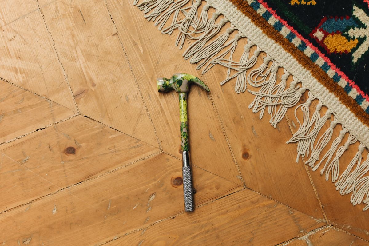 A rug with a hammer on a wooden floor