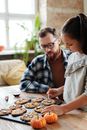 A Girld Decorating Cookies With Her Father