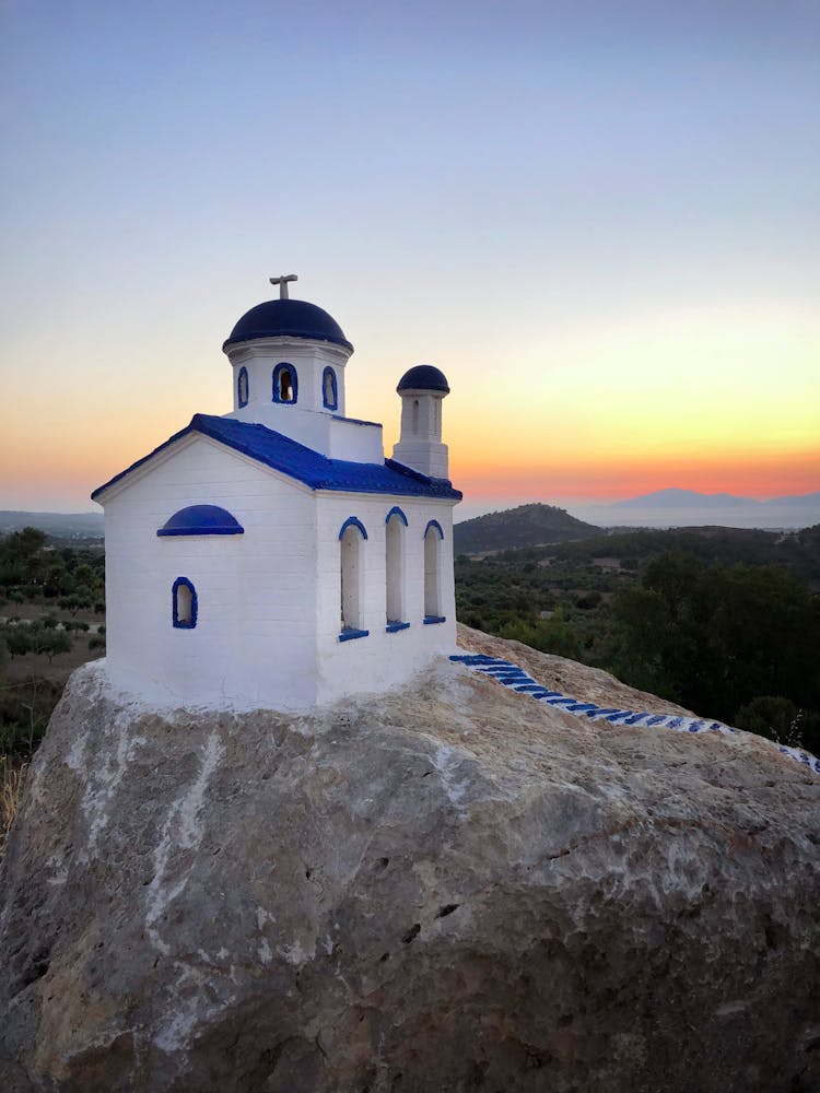 White And Blue Old Chapel On A Rock At Dawn