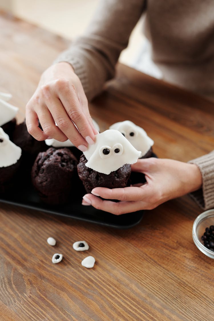 Person Decorating A Chocolate Cupcake