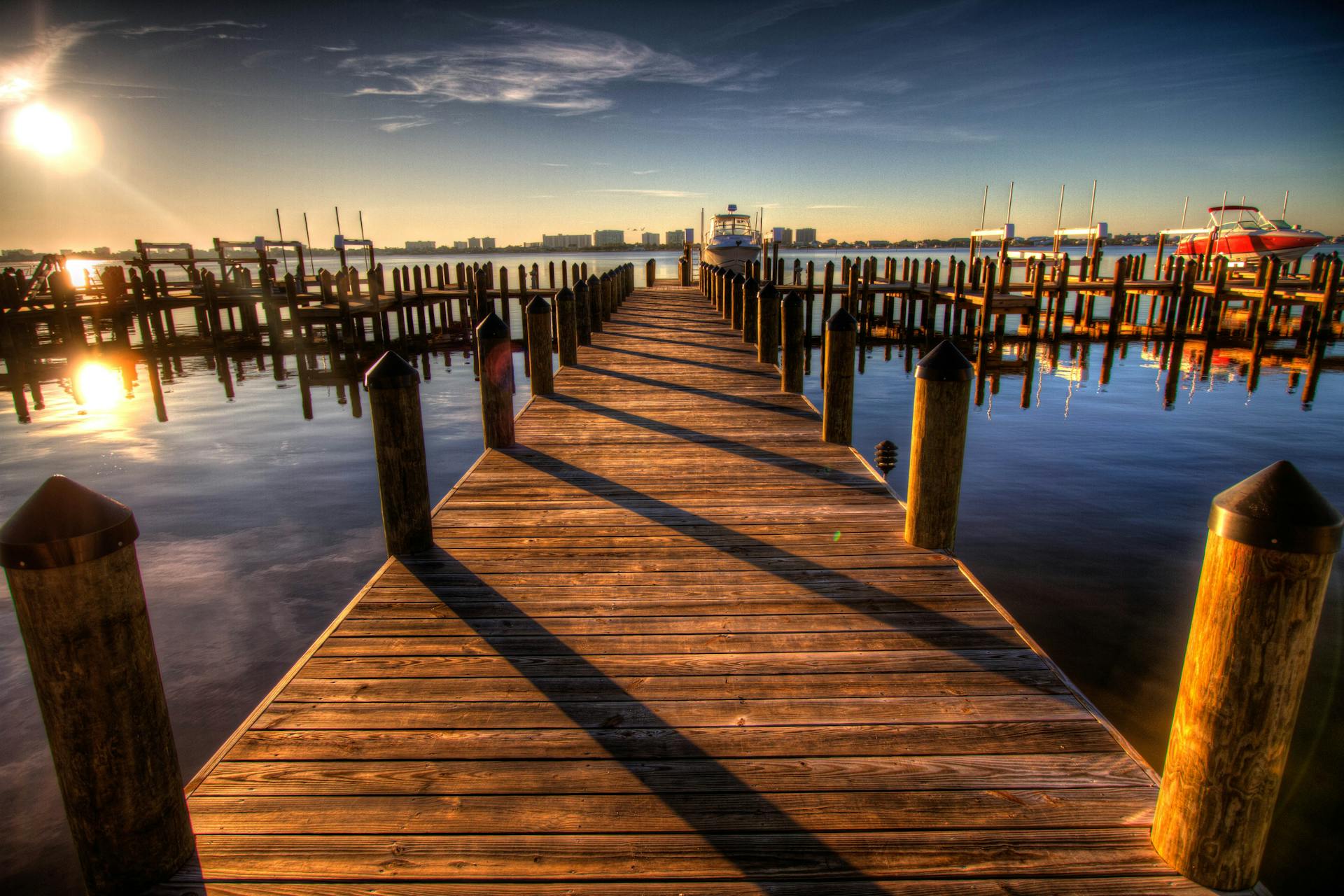 Peaceful harbor scene with docks at sunset, showcasing reflections on the water.