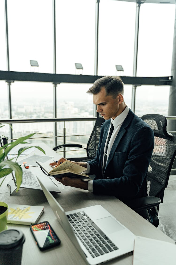 A Man Looking The Notebook In The Office