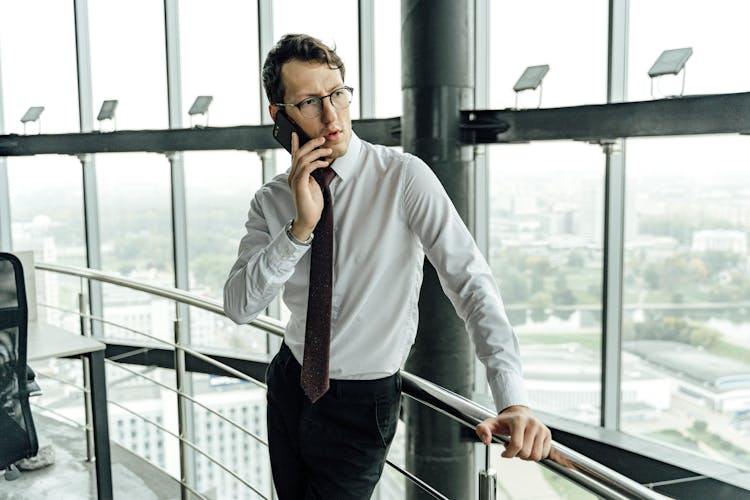 Man In White Long Sleeves Talking On The Phone