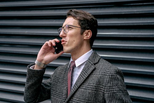 A Man in Checkered Suit Talking on the Phone
