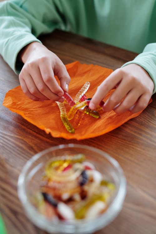 Person Wrapping Gummies In An Orange Paper