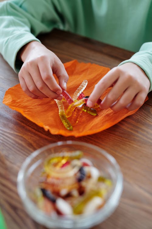 Personne Emballant Des Bonbons Gélifiés Dans Un Papier Orange