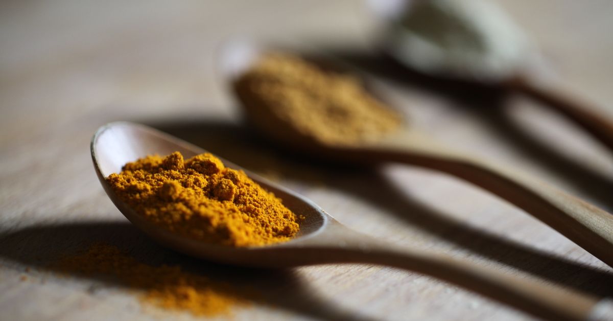 Turmeric powder on a wooden spoon
