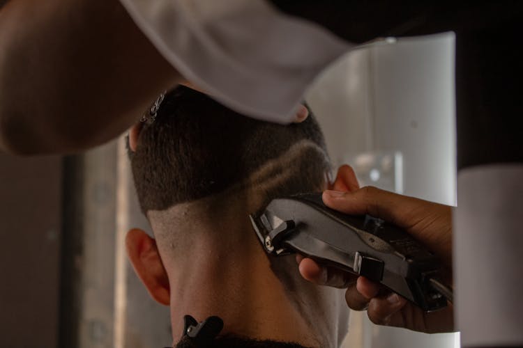 Close Up Of Hairdresser Uses Hair Trimmer