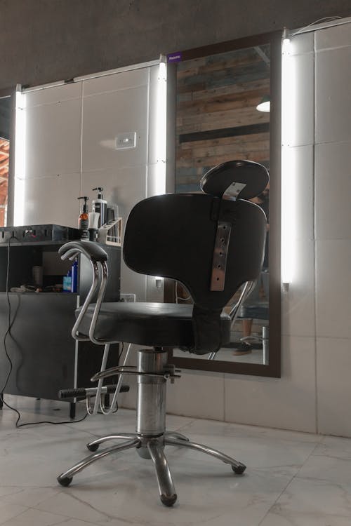 Free A Barber Chair Near a Mirror with Lights Stock Photo