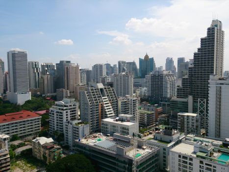 Aerial view of a vibrant cityscape showcasing modern high-rise buildings under a clear sky.