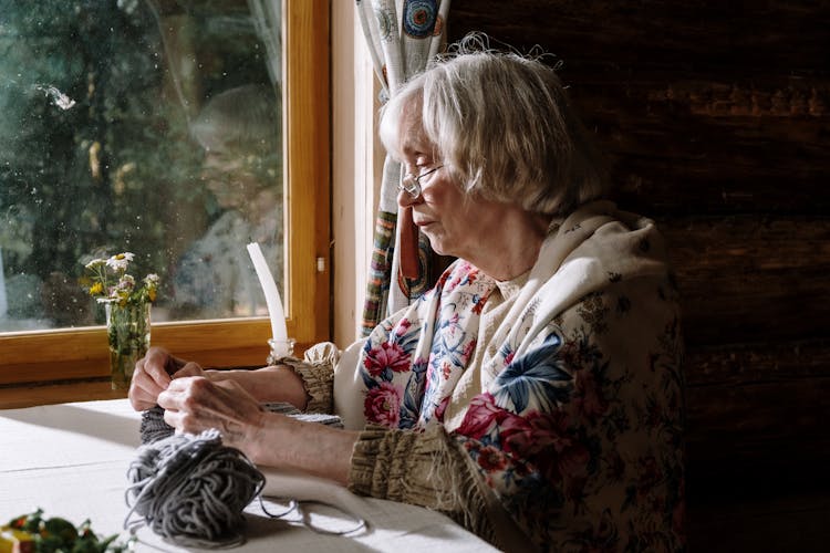 Elderly Woman Sitting Beside A Window