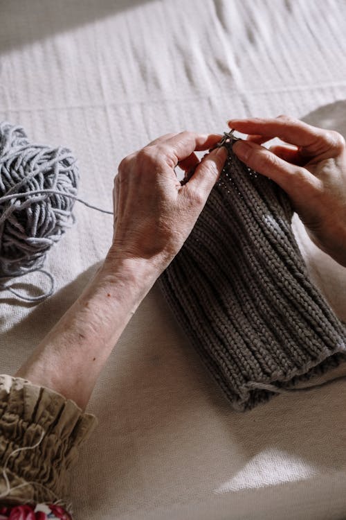 Person Knitting a Gray Thread